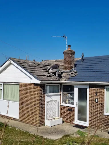Bungalow roof mid-repair with old tiles being replaced