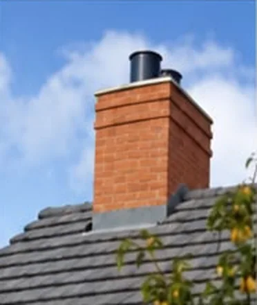 Rebuilt red brick chimney stack with new lead flashing on a grey tiled roof