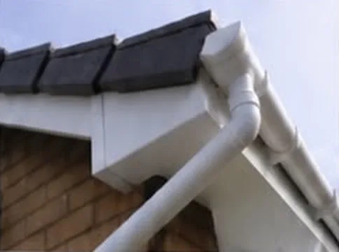 White uPVC fascia board, soffit and guttering under a tiled roof edge
