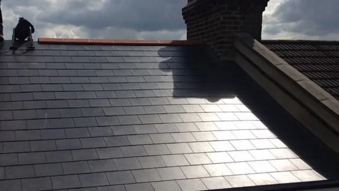 New slate roof laid up to a brick chimney stack