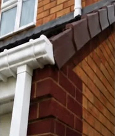 White uPVC gutter and downpipe on a red brick house